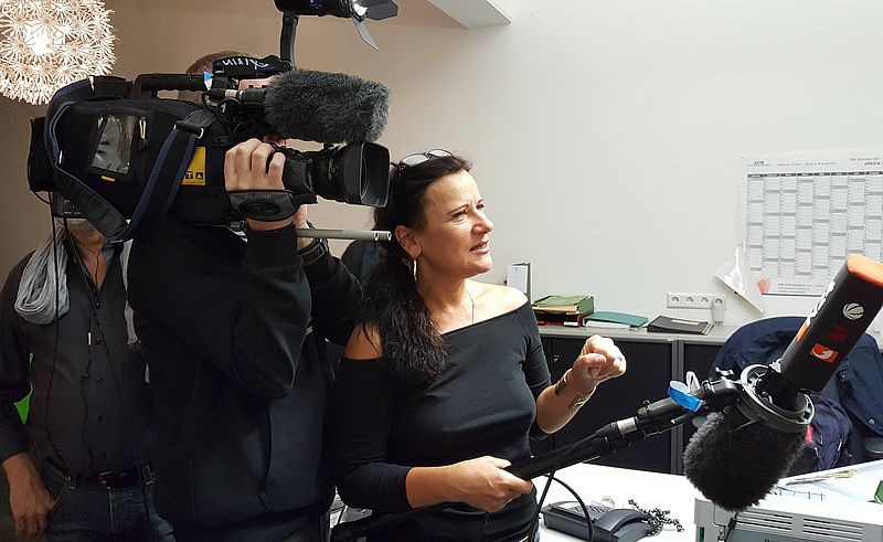 Journalistin mit Mikrofon und Kameramann mit großer Fernsehkamera