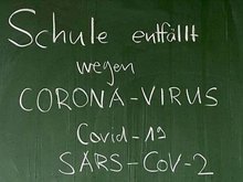 Schultafel mit der Aufschrift: Schule entfällt wegen Corona-Virus.