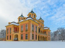 Foto von Schloss Favorite in Winterlandschaft mit Schnee und blauem Himmel