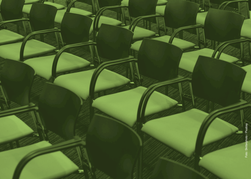 Grün eingefärbtes Bild von leeren Stuhlreihen.