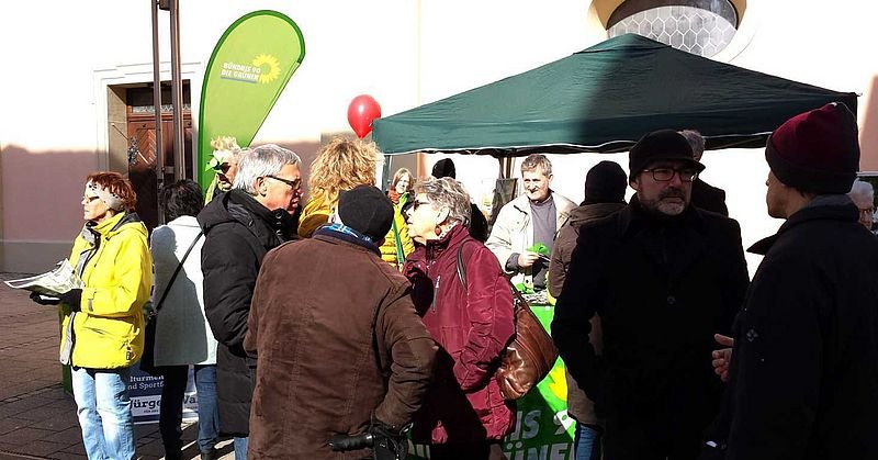 Foto von Menschen im Gespräch an einem Infostand der Grünen