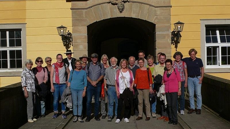 Gruppenfoto von ca. 20 Personen vor einer Toreinfahrt