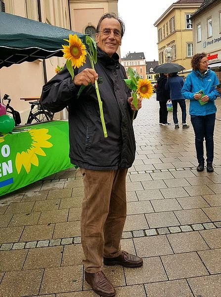 Klaus Hoffmann mit einer Sonnenblume vor dem Infostand