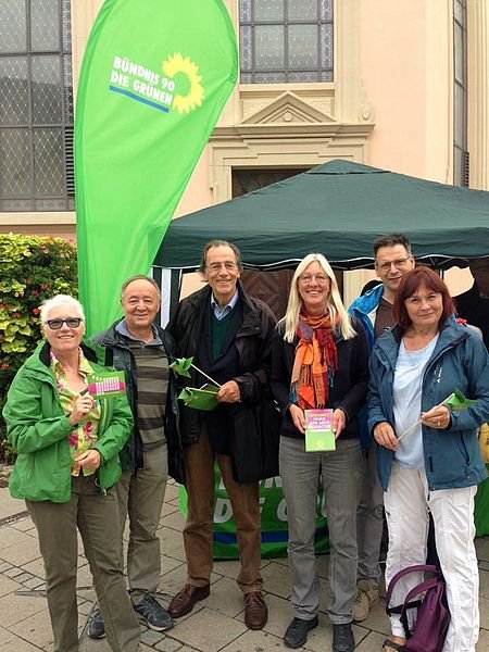 Gruppenbild von mehreren Personen vor dem Infostand der Grünen